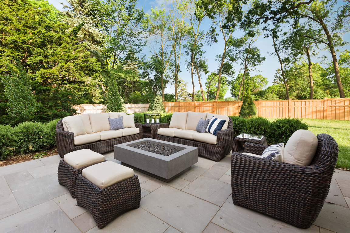 Outdoor patio area with comfortable seating around a gas firepit